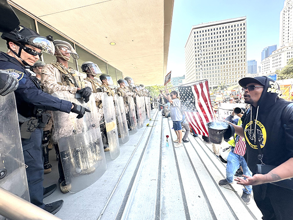 National Guard troops and U.S. Marines are confronted outside the downtown Federal Building by protesters earlier this month.