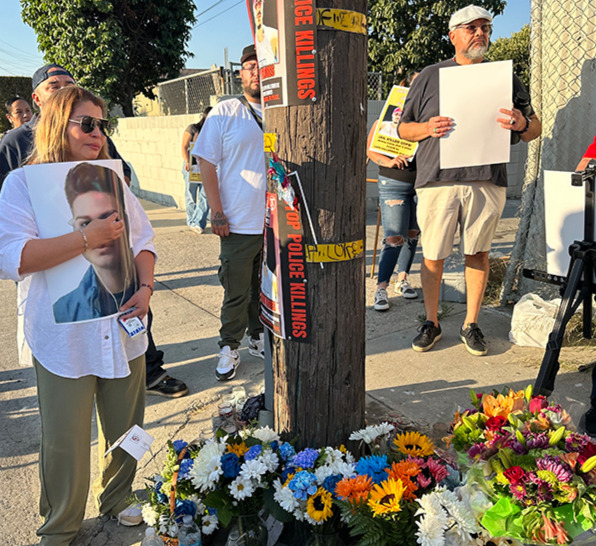 Isabella Rivera, the mother of Jeremy Flores, holds a picture of her at a vigil in Boyle Heights July 15.