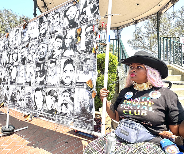 Stardinasia Jackson rests during a downtown protest July 13 of federal immigration policies. She is seated next to a mural of people who have been detained by federal immigration during the past six weeks in Los Angeles.