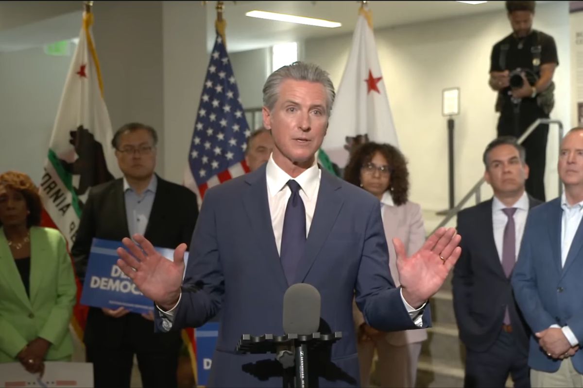 California Gov. Gavin Newsom stands in front of microphones as he introduces a new proposal to redraw the state’s Congressional districts.